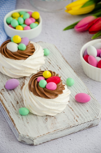 Foto mini nido de pájaros pavlova con crema de chocolate y caramelo de colores