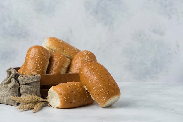 Mini pão italiano de café da manhã em caixa de madeira na composição de fundo branco