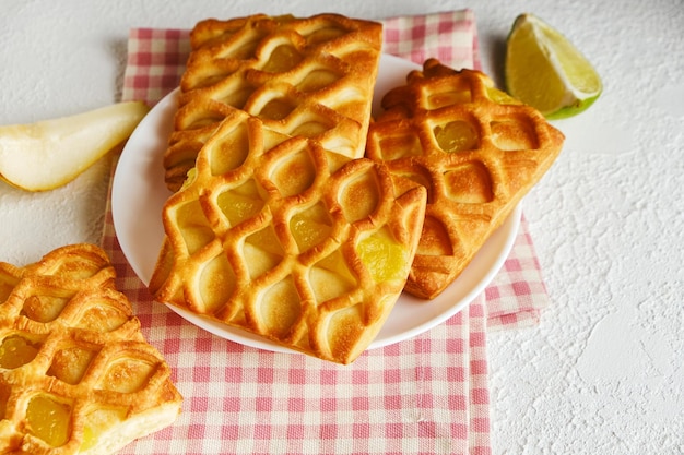 Mini pasteles de hojaldre con relleno de mermelada de pera y lima en un plato blanco