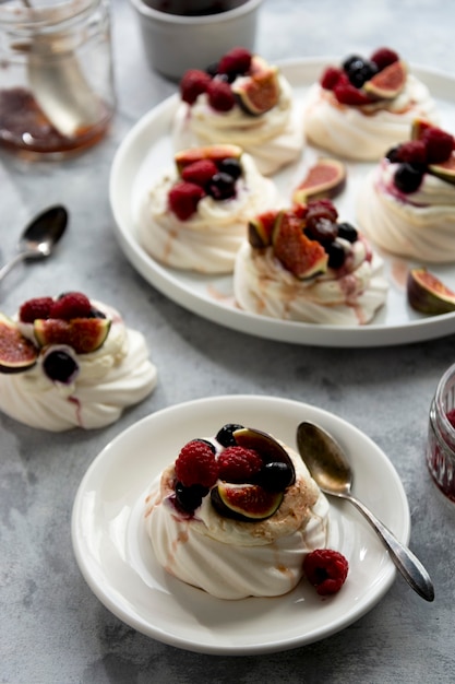 Mini Pavlova Baiser Kuchen mit Beeren und Feigenfrüchten verziert