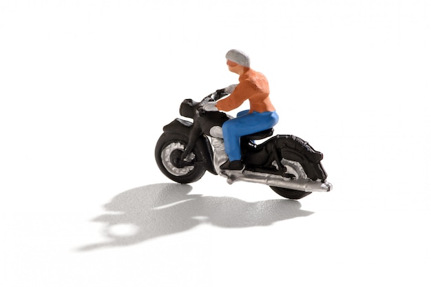 Mini Person, die ein Motorrad mit Schatten reitet