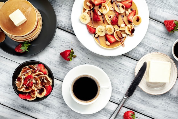 Mini-Pfannkuchen mit Erdbeeren und Bananen auf einem Teller auf dem Tisch