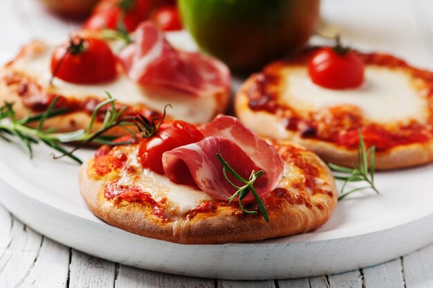 Mini pizza con mozzarella, jamón serrano y tomate