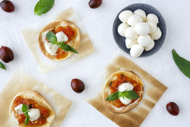 Mini pizzas margarita caseras con tomate, mozzarella y albahaca