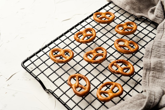 mini pretzels salgados no fundo branco do rack de resfriamento de arame. biscoitos duros ou lanches