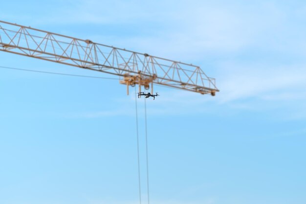 Foto mini-quadcopter fliegen auf dem himmel, um die überwachung von der baustelle aus zu überwachen.