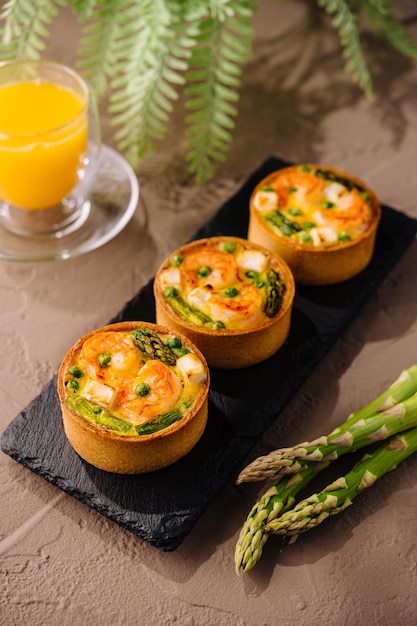 Mini quiches sabrosos con espárragos y jugo de naranja