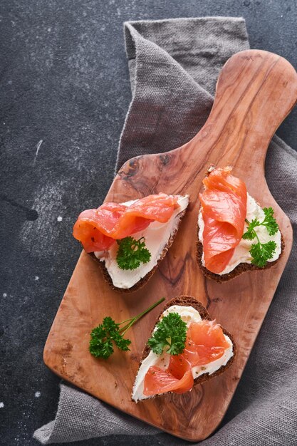 Mini-Sandwiches mit Lachsquark, Petersilie und Roggenbrot in Form von Herzen Valentinstag hausgemachtes kreatives Essen Liebe Frühstücksdesign Selektiver Fokus und Kopierraum