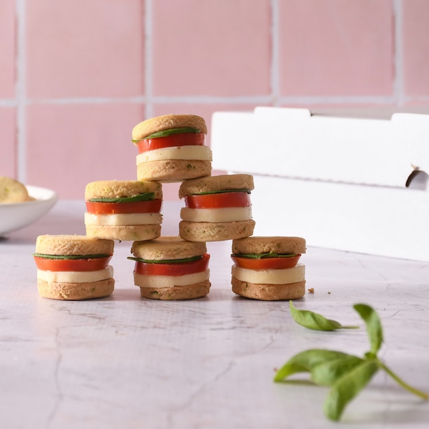 Mini sándwiches con tomate y queso.