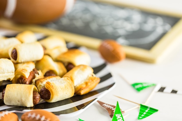 Mini-Schweine in einer Decke für Fußballspielparty.