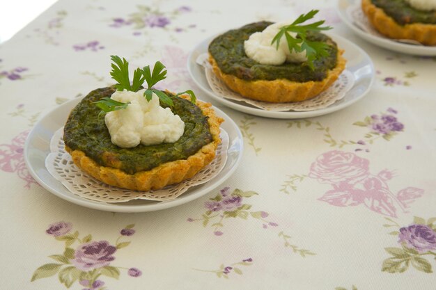 Mini tartas caseras de espinacas y ricotta en una servilleta decorativa blanca