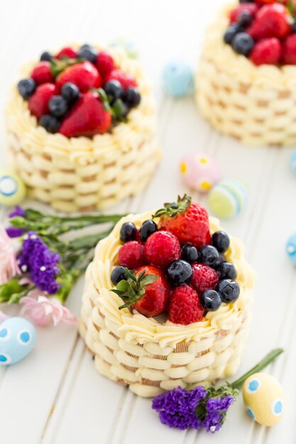 Mini tortas de canasta de Pascua con fruta fresca glaseada en la parte superior.