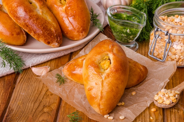 Mini tortas de fermento tradicionais russas e ucranianas com ervilhas e molho de alho. estilo rústico.