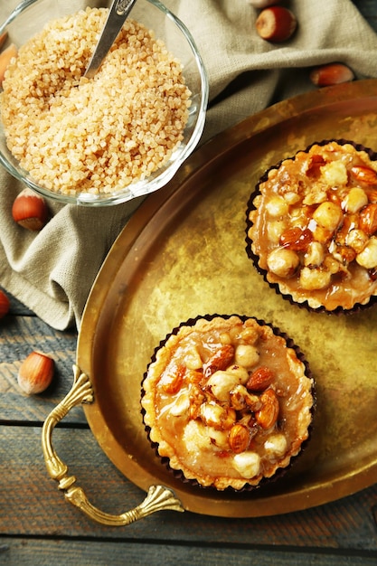 Mini tortas con nueces en una servilleta sobre fondo de madera