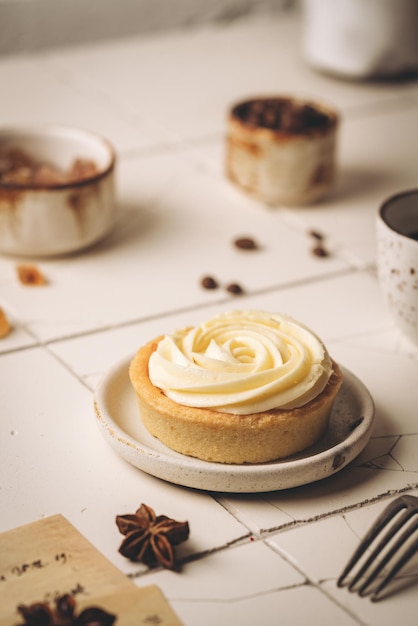 Mini-Torte mit Schlagsahne und süßem Zitronendessert auf weißem Teller