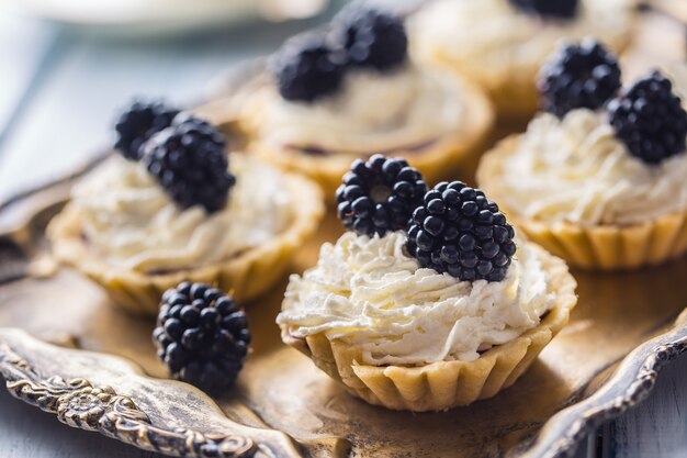 Mini tortinhas com chantilly de amoras e café.