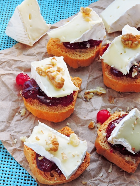 Mini tostadas con mermelada de arándanos, camembert y nueces.