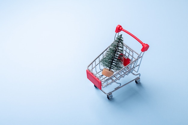 Mini-Trolley-Wagen-Kopie auf blauem Hintergrund mit Tannenbaum Konzept des Weihnachtsverkaufs Draufsicht Textfreiraum - Image