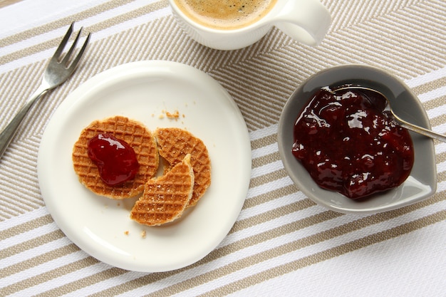 Mini waffles de stroopwafels com xícara de café e geléia
