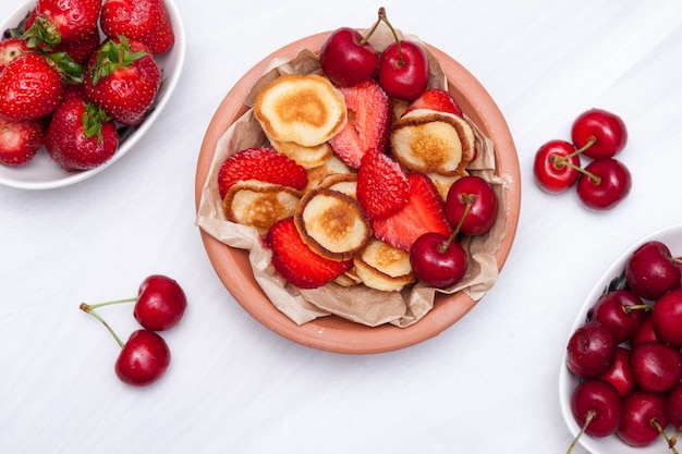 Mini winzige Pfannkuchen mit Erdbeeren und Kirschen