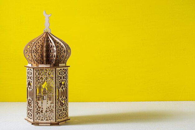 Miniatur-Moscheelampe aus Holz mit gelbem Hintergrund Leerraum für Text Ramadhan Kareem