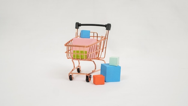 Miniatur-Trolley gefüllt mit bunten Kisten und Mini-Taschen isoliert auf weißem Hintergrund