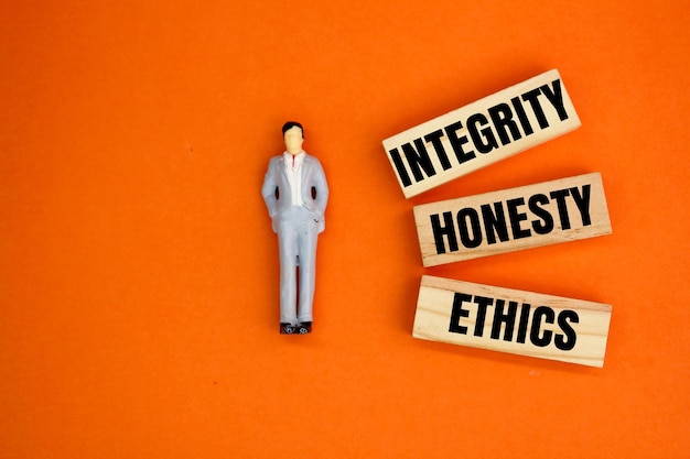 Miniatur- und Holzmenschen mit den Worten Integrität, Ehrlichkeit und Ethik, Konzept der Arbeitsethik