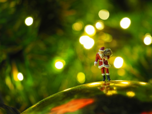 Miniatur-Weihnachtsmann mit schönen Licht Bokeh Hintergrund. Weihnachts- und guten Rutsch ins Neue Jahr-Konzept.