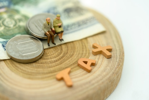 Miniatura de ancianos sentados en la pila de monedas con una redacción