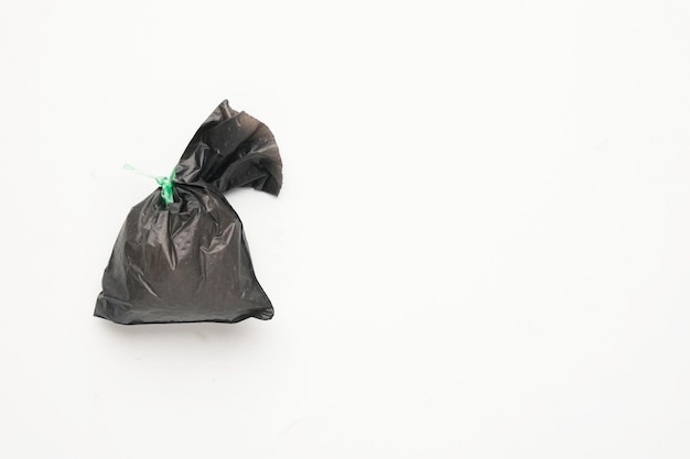 Foto una miniatura de una bolsa de basura negra en un fondo blanco de copyspace