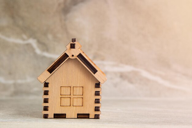 Miniatura de casa de madera sobre fondo de piedra de mármol. Copie el espacio. foto de estudio. Concepto de hipoteca. Casa Símbolo. concepto de bienes raíces. Casa Eco Amigable.