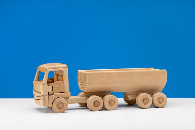 Foto miniatura de carro feito de brinquedo de madeira para crianças fundo azul tiro de estúdio