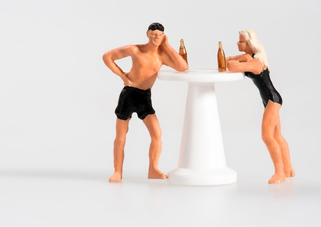 Miniatura de homem e mulher bebendo em um quiosque