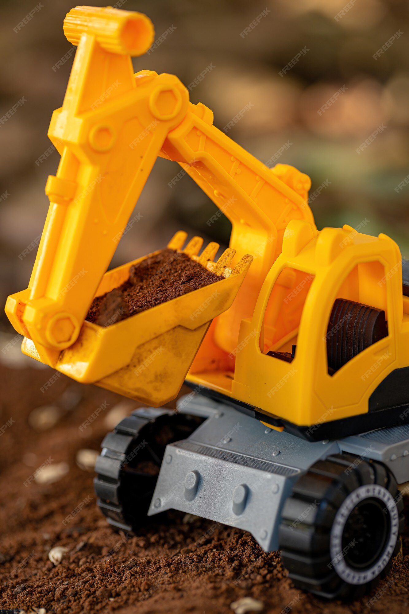 cascada Nominación Interpersonal Miniatura de excavadora de juguete de color amarillo y negro en el suelo  con enfoque selectivo | Foto Premium