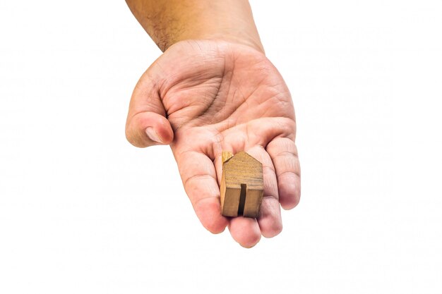 Miniatura de madera de la casa con la mano sobre fondo blanco