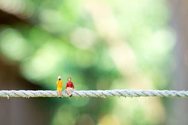 Miniatura pessoas casal mulher sentada na natureza verde