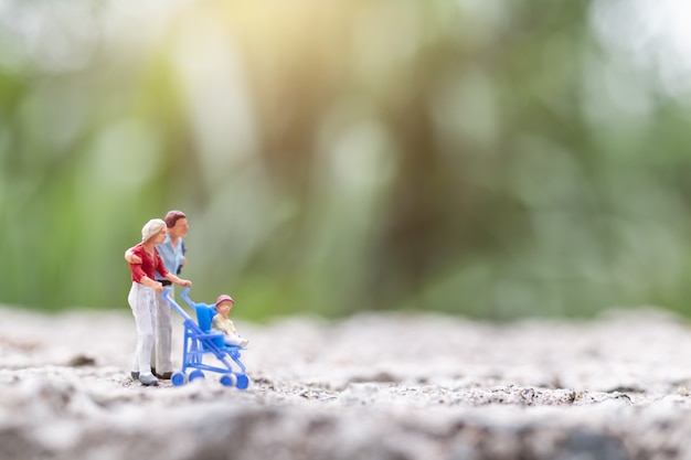 Miniatura pessoas: pais com filhos caminhando ao ar livre