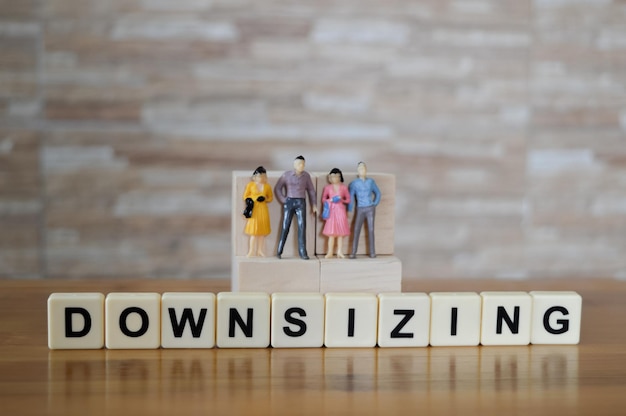 Miniaturas de personas y letras cuadradas con texto DOWNSIZING