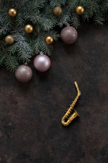 Miniaturgoldene Saxophonkopie Tannenzweige und weihnachtliche rosa Bälle