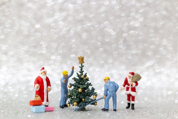 Foto miniaturleute: arbeitskraftteam bereiten weihnachtsbaum vor