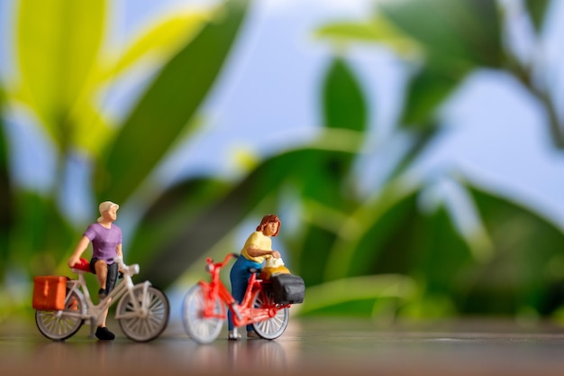Miniaturmenschen, die mit dem Fahrrad stehen Weltfahrradtag-Konzept