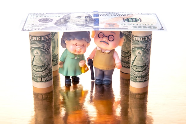 Foto miniaturmenschen ein paar rentner unter dem haus der dollar finanzielle sicherheit und rente für ältere menschen konzept der finanziellen unabhängigkeit
