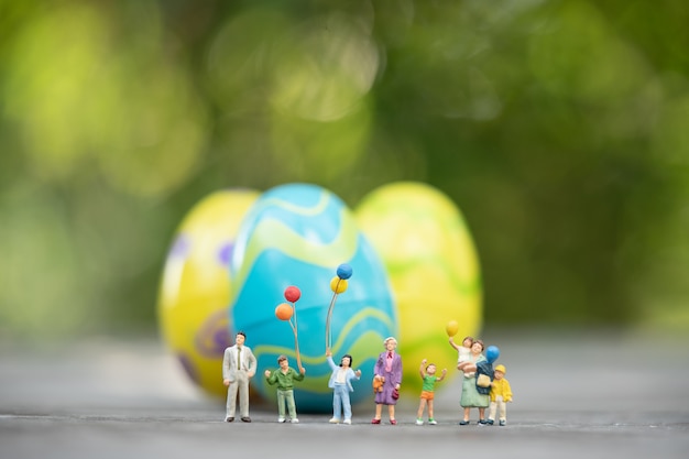 Miniaturmenschen, Familie, die Ostertag mit bunten Ostereiern feiert