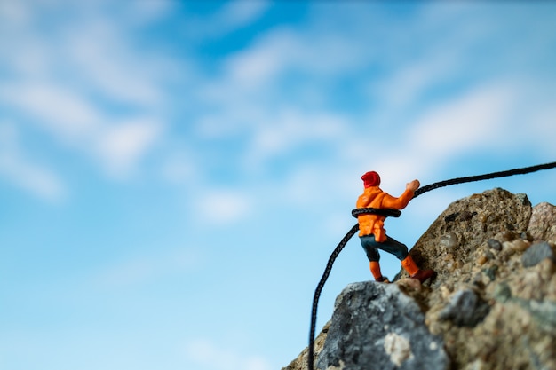 Miniaturmenschen: Wanderer klettern auf den Felsen. Sport- und Freizeitkonzept.