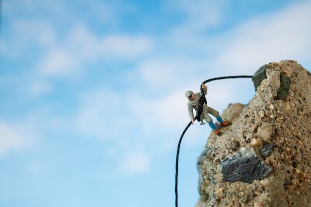 Miniaturmenschen: Wanderer klettern auf den Felsen. Sport- und Freizeitkonzept.