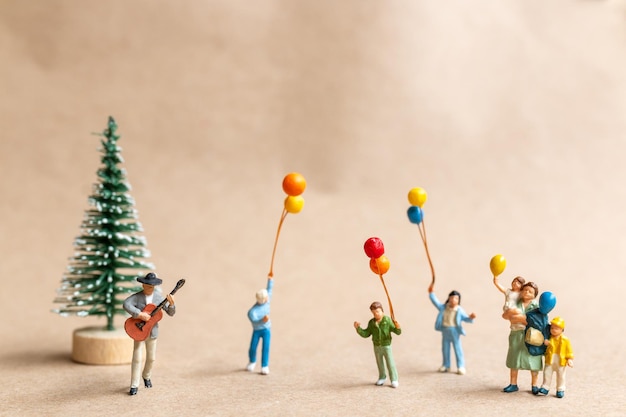 Miniaturmusiker mit einer Gitarre in den Parkkonzepten von Weihnachten und von einem guten Rutsch ins neue Jahr