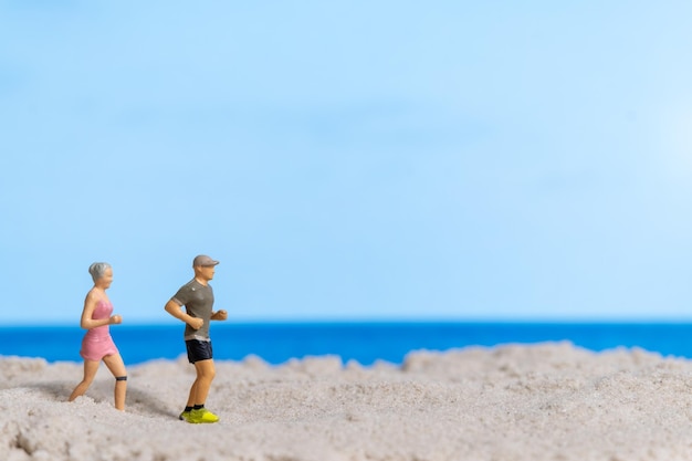 Miniaturpaar, das zusammen am Strand läuft