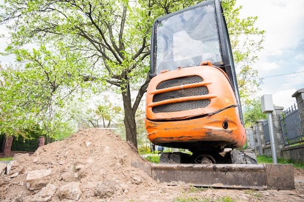 Minibagger in oranger Farbe. Vermietung von Baumaschinen.