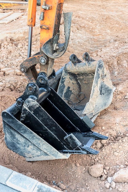 Minibaggerschaufel mit Zusatzwerkzeug für Arbeiten auf der Baustelle. Kompaktes Baugerät für den Erdbau.