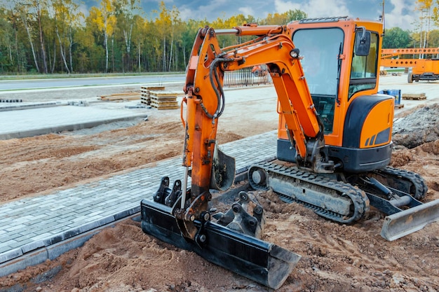 Miniexcavadora en el sitio de construcción Equipos de construcción compactos para movimiento de tierras